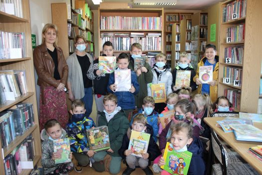 Zdjęcie przedstawia dzieci z drugiej klasy Zespołu Szkolno Przedszkolnego im. Tadeusza Kościuszki w Stroniu na wizycie w Bibliotece Publicznej w Stroniu z okazji święta Pluszowego Misia.