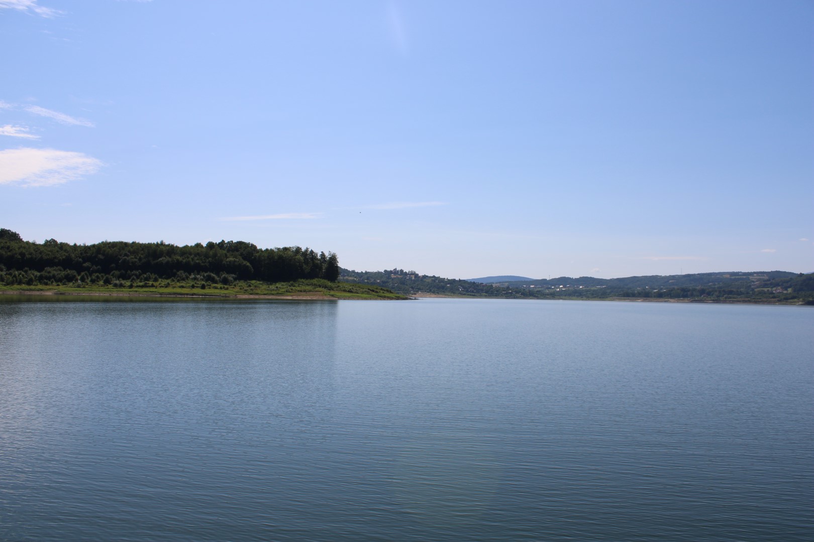 Zdjęcie przedstawia Jezioro Mucharskie w słoneczny dzień, zdjęcie zostało zrobione ze statku.