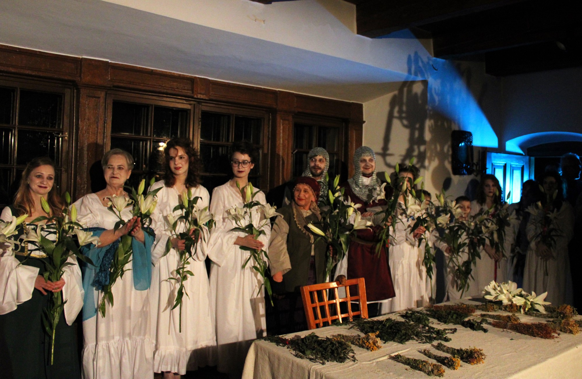 Na zdjęciu znajdują się aktorzy po zakończonym spektaklu „Lilije”, trzymają w ręku kwiaty białych lilii, które otrzymali za niesamowitą grę aktorską.